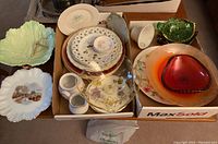 Box with assorted plates, saucers, cups, leaf plate, and glass bowls