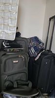 Gray Air Canada luggage, black wheeled garment bag, black luggage with wheels, and a shoulder bag partially visible