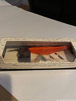 Calligraphy set in original box including orange feather quill, glass ink well, and four nibs.
