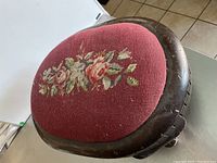 Top view showing oval red needlepoint fabric with floral design