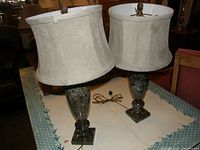 Two marble table lamps on a table, showing the overall look with shades attached and cords visible