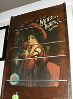 Front view of the wooden slatted sign showing the vintage Wunder Beer advertisement with a woman in red and branding text.
