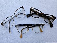 Three pairs of reading glasses displayed on a white background showing various frame designs and colors.