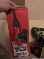 Photo of Milwaukee 4 1/2 inch angle grinder in its original red box with branding and label visible.