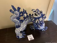 Porcelain dragon figurine viewed from the side showcasing detailed scale pattern and open mouth expression.