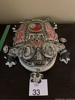Front and top view of a large ceramic frog sculpture featuring detailed black and red painted decorations with a Yin-Yang symbol and butterfly.