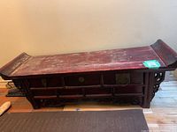 Full side view of the wooden bench showing front drawers and worn reddish finish.