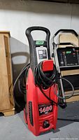 Front view of the red and black Clean Force 1400 PSI power washer showing handle, attached hose, and power cord.