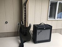 Front view of bass guitar and amplifier on table against wall