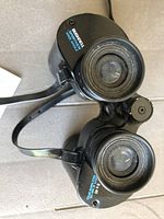 Close-up of lens and model markings on Bushnell binoculars.