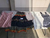 All five clothing items laid on a table outdoors in sunlight