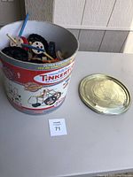 Photo of vintage Tinkertoy set in original metal can with lid placed next to it