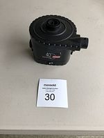 Black 4D Quick Pump device placed on a white surface with a MaxSold auction tag.