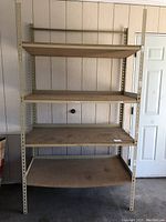 Full front view of shelving unit assembled showing 5 corkboard shelves and light metal frame.