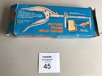 Blue boxed cast aluminum picture frame brad driver tool with original packaging.