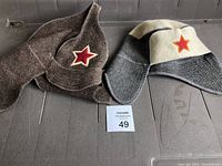 Two wool sauna hats placed side by side, showing their unique Russian motif red star patches and wool textures.