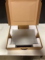 MS210-48FP switch seated in open cardboard box with foam inserts