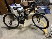 Full side view of the Hyper Havoc mountain bike showing black frame, tires, seat, and handlebar with damaged gear shift.