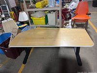 Full view of IKEA Bekant office table with wood grain finish top and black legs, showing condition and overall shape.