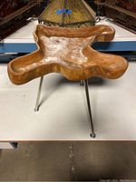 Front view of the driftwood accent table showing organic shape and stainless steel legs.