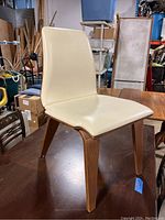 Side angled view of the chair showing wooden legs, padded seat and back, and minor surface scratches.