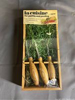 Full view of La Cuisine by Imperial paring and peeling set in original packaging with three utensils and green decorative filler.