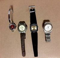 Four wristwatches laid flat showing variation in face color, strap materials, and design.