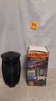 Photo of the Stinger insect killer bug zapper and its original box side by side, showing the actual product and packaging.
