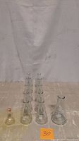 Ten 250ml Fisherbrand flasks arranged in two rows and one 125ml Pyrex flask with amber stopper at front