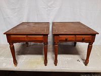 Front view of the two wooden end tables side by side showing drawers and legs