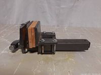 Side view of the metal table vise with wooden jaw pads and tightening handle