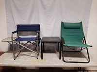 Front view of two folding chairs and small black metal table between them