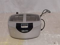 Front view of the Chicago Electric Power Tools ultrasonic cleaner showing digital timer and clear lid with divider.