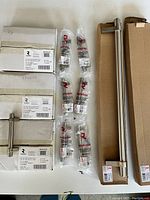 Photo showing multiple boxes labeled Richelieu with brushed nickel cabinet pulls and two long appliance pulls in original packaging.