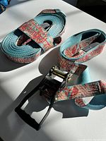 Close-up photo of the blue and red Absolute Slacklines webbing with a metal ratchet tensioner on a white surface showing good condition and branding details.