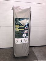 Packaged rollaway bed in wheeled carrying case with product label showing brand and image of bed setup.