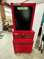 Front view of three-piece red metal tool storage set on casters