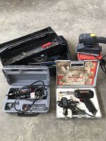 Overview of all tools in lot including toolbox, Dremel kit, soldering kit, and sander