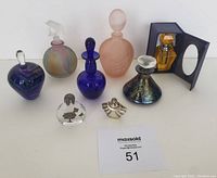 Photo showing all 8 assorted refillable perfume bottles in varying sizes and styles placed together.