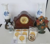 Lot view showing all items including clock, lamps, figurine, plates, and door stop