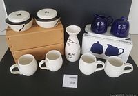 Full lot showing mugs, cream & sugar set in box, lidded bowls in boxes, and vase