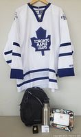 Front and back view of the white CCM Toronto Maple Leafs hockey jersey, size adult XL, with blue stripes and blue Maple Leafs logo on front.