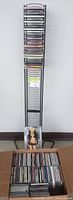Tall metal CD holder with multiple CDs stored in the rack; metal vertical design with many slots.