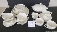 Complete collection of Wedgwood Tranquility bone china dinnerware pieces arranged together showing cups, saucers, plates, bowls and the large covered bowl.