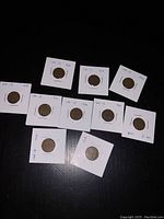 Photo showing ten Canadian pennies from 1930 to 1939, each housed in protective holders and labeled with their dates. Coins show weathered condition with patina and wear visible on all.