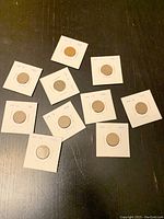 Photo showing all ten Canadian pennies from 1940s individually mounted in white cardboard holders, labeled by year.