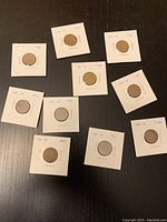 Image showing ten Canadian pennies from the 1950s, each mounted in a white coin holder with visible dates.