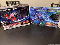 Two boxed toys: AirHogs FPV Race Drone and Toothless Giant Fire Breathing Dragon toy from How to Train Your Dragon.