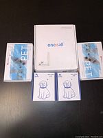 Photo shows a white Onesall box, two PET dog card packs, and two Bulk Color Art card sets featuring dog drawings.