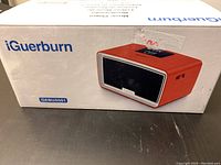 Photo of the iGuerburn music player box featuring the product image, brand name, and model number GEBUS051.